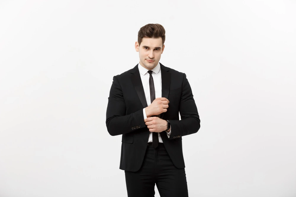 Man adjusting cuff in a black suit
