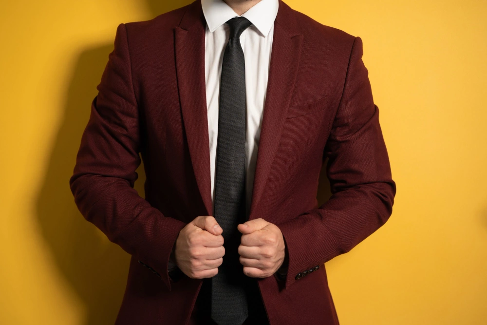 Man in Burgundy and Maroon suit against yellow background